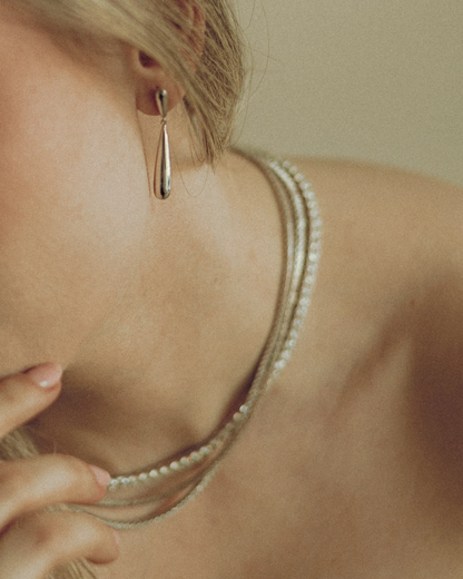 Goldmacher Long Drop Earrings – Smooth gold teardrop hoops styled on model for a refined, modern look