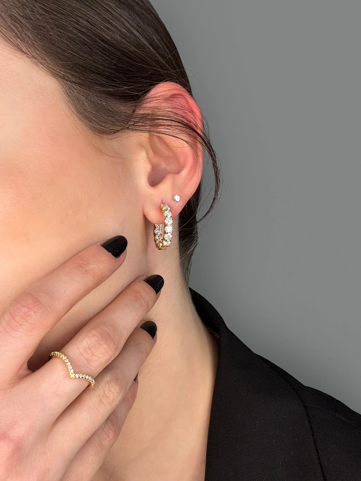 Modern styling of Goldmacher moissanite hoop earrings, tennis chain, and layered rings (heart, pavé, V-shaped)